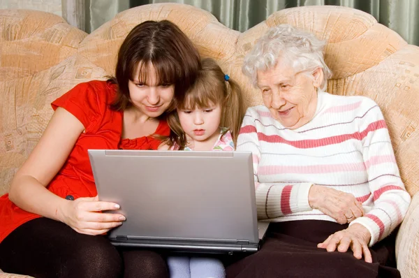 Family on a sofa with computer — Stock Photo, Image