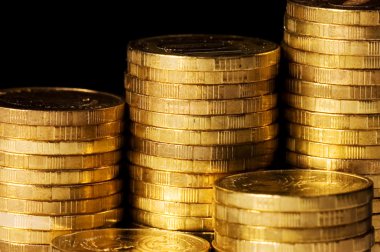 Golden coins isolated on black background clipart