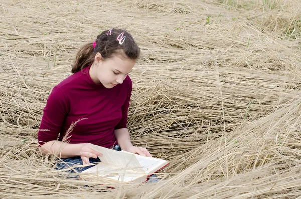 La muchacha lee el libro sobre la hierba — Foto de Stock