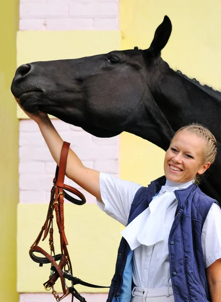 Girl and black sportive horse before competitions — Stock Photo, Image