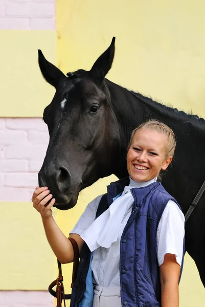 Meisje en zwarte sportieve paard voor competities — Stockfoto