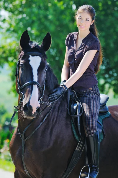 Giovane ragazza cavalcando nero sport cavallo — Foto Stock