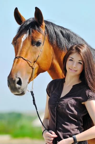 Menina jovem e cavalo baía — Fotografia de Stock