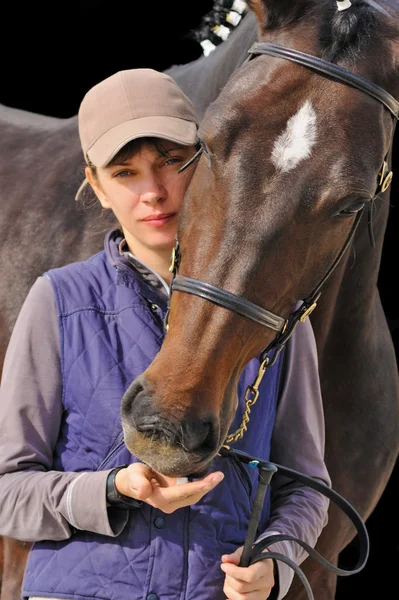 Flicka med bay häst, på svart bakgrund isolerade — Stockfoto