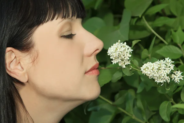Joven mujer disfrutando oliendo aroma flores — Foto de Stock