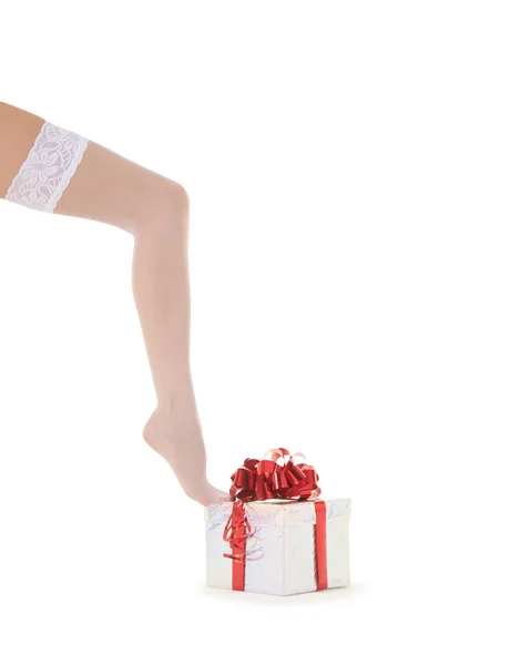 Donna gamba in calze bianche con regalo sopra bianco — Foto Stock