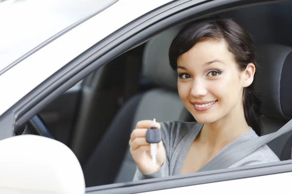 Pretty girl in a car showing the key — Stock Photo, Image