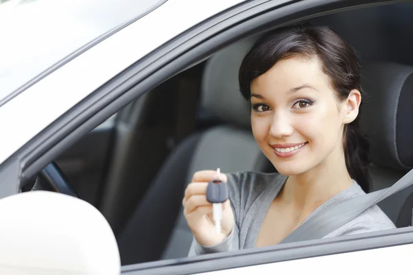 Pretty girl in a car showing the key — Stok fotoğraf