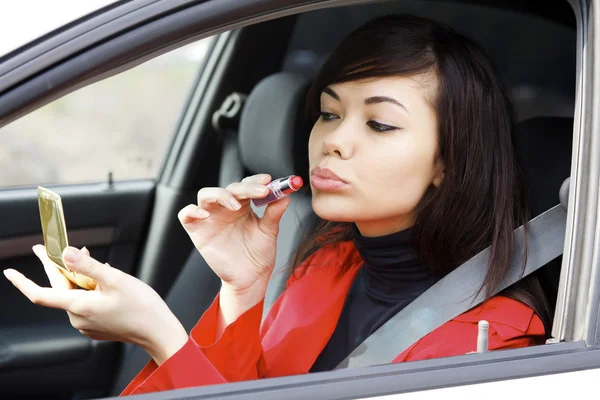 Pretty caucasian woman in a car doing makeup. — Stock Photo, Image