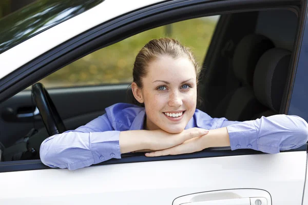 Ganska kvinnliga föraren i en vit bil — Stockfoto
