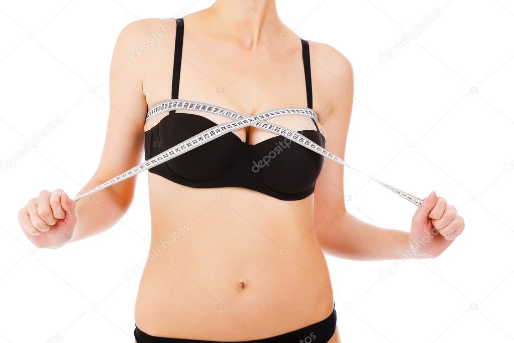 Woman measures breast by measurement tape.