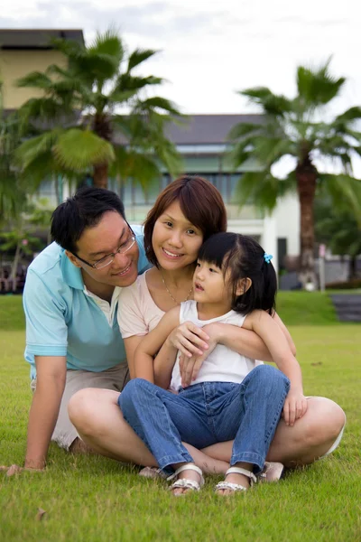 Happy family sits on grass field — Stock Photo, Image