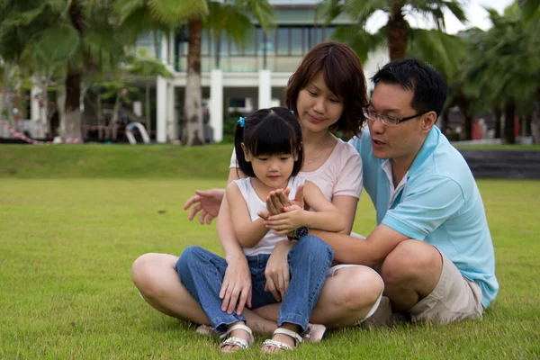 Lycklig familj sitter på gräsplan — Stockfoto