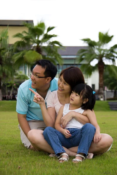 Szczęśliwa rodzina siedzi na boisko — Zdjęcie stockowe
