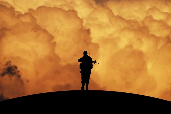 Silueta osamělý voják s dramatické nebe za úsvitu — Stock fotografie