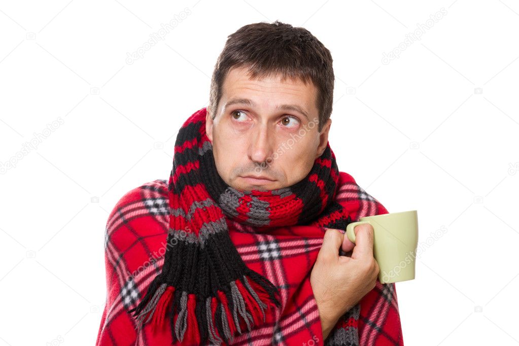 Colds man wrapped in blanket, holding a mug