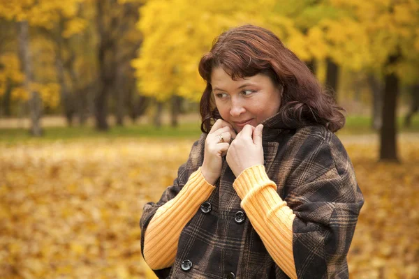 Portret van mooie vrouw tegen oranje bladeren — Stockfoto