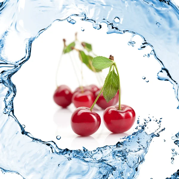 Röda körsbär med blad och vattenstänk isolerad på vit — Stockfoto