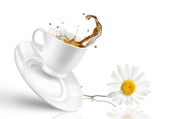 Un soupçon de thé dans la tasse tombante avec une fleur isolée sur du blanc — Photo