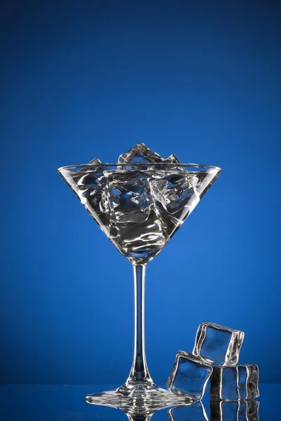 Vaso de martini con hielo sobre azul — Foto de Stock