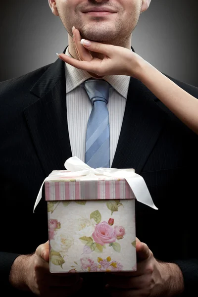 Closeup portrait of businessman holding gift with womans hand — Stock Photo, Image