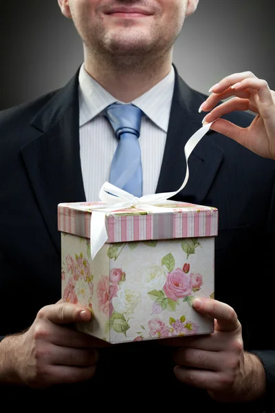 Detailní portrét podnikatele drží dárek rukou Zenske — Stock fotografie