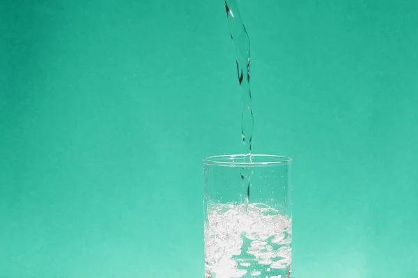 Egy pohár víz zöld háttérrel — Stock Fotó