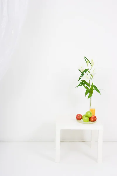 Apples, a glass of juice and lilies — Stock Photo, Image