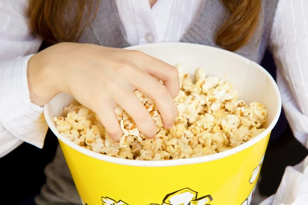 Hand in een emmer popcorn — Stockfoto