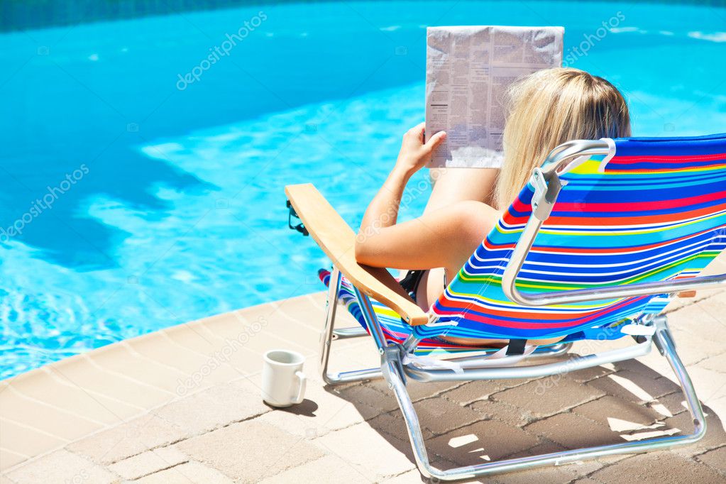 The woman is sitting near the pool