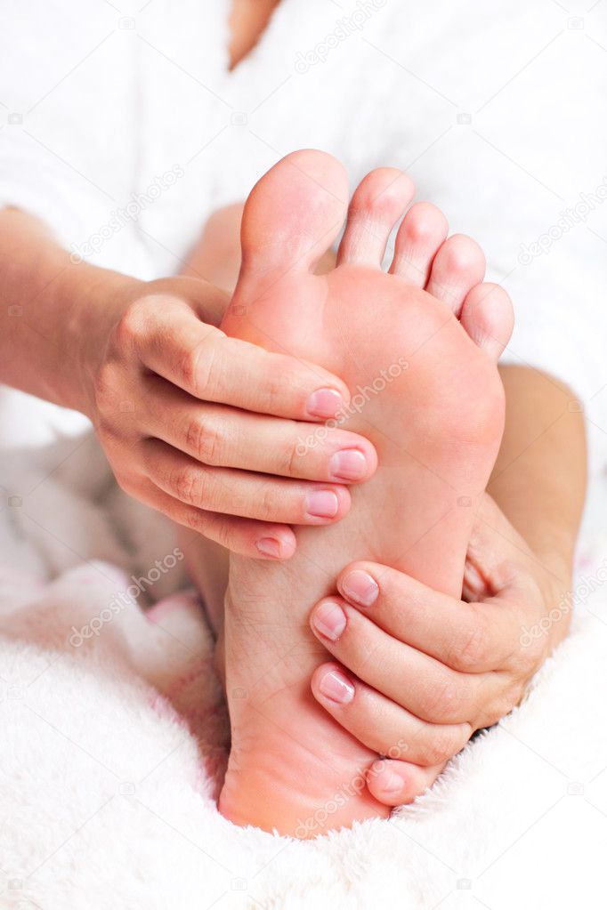 Woman massaging his feet