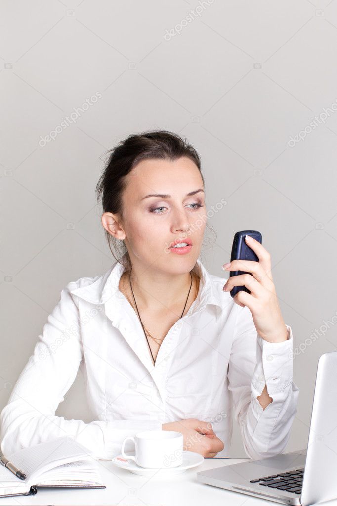Portrait of a smiling young business woman speaking on cell-phon
