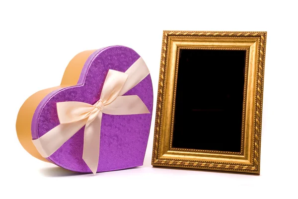 Gouden frame en cadeau doos op een witte achtergrond — Stockfoto