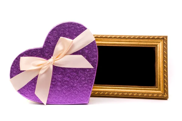 Gouden frame en cadeau doos op een witte achtergrond — Stockfoto