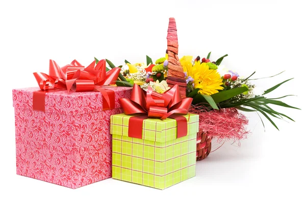 Beautiful bouquet in the basket and present boxes on a white bac — Stock Photo, Image