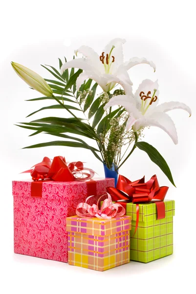 Hermoso ramo de lirios blancos y cajas de regalo en un b blanco — Foto de Stock