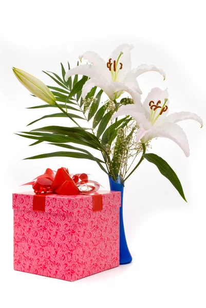 Schöner Strauß weißer Lilien und Geschenk-Box auf einem weißen Bac — Stockfoto
