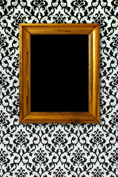 Gold frame on a black and white wallpaper — Stock Photo, Image