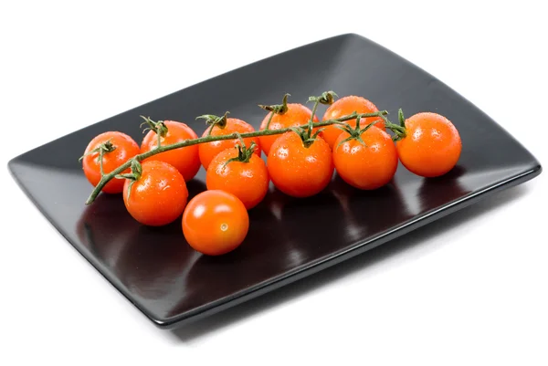 Tomates cherry en un plato negro — Foto de Stock