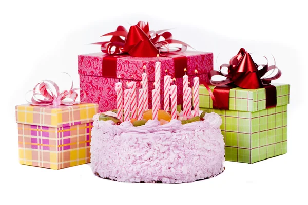 Torta con dodici candele e regali in scatole su sfondo bianco — Foto Stock