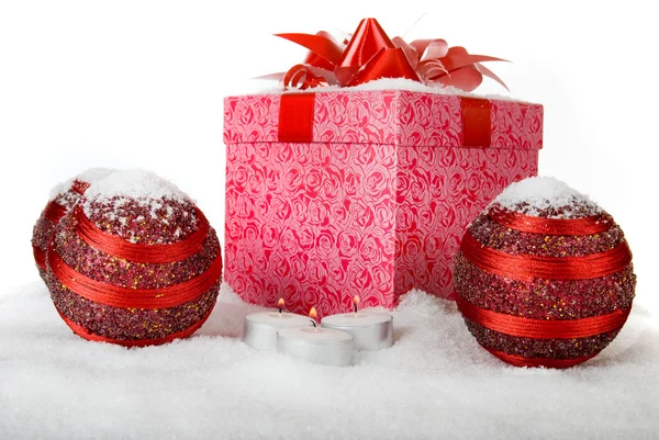 Caja de regalo de Navidad en la nieve con bolas rojas y velas —  Fotos de Stock