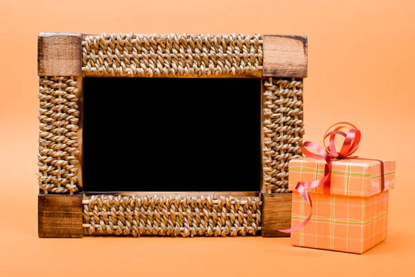 Foto frame en gift box met lint op gele achtergrond. — Stockfoto