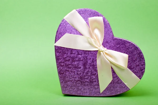 De doos van de gift van één hart met lint op groene achtergrond. — Stockfoto