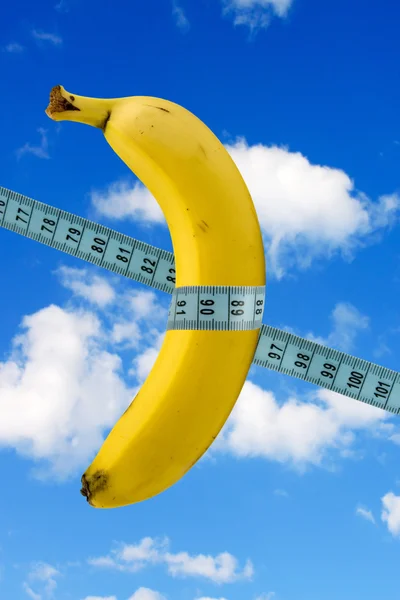 Banana con nastro di misura sullo sfondo del cielo — Foto Stock