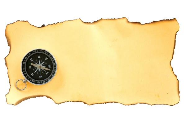 Kompas op het stuk van verbrand papier — Stockfoto