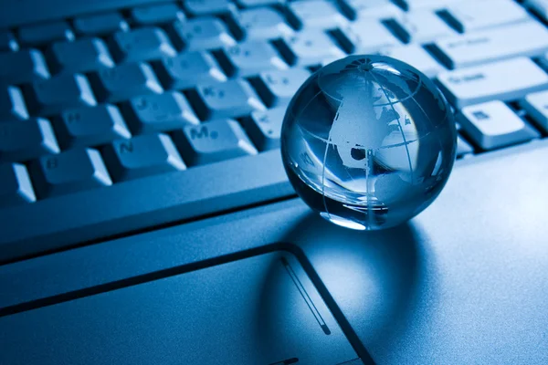 Transparent globe on a laptop keyboard — Stock Photo, Image
