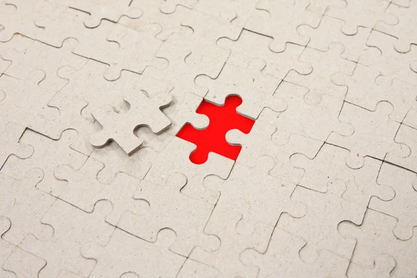 Papper puzzle with red piece missing — Stock Photo, Image