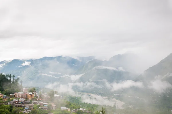 Nevoeiro em um vale entre altas montanhas — Fotografia de Stock