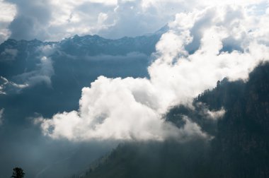 Mountain peak shrouded in clouds clipart