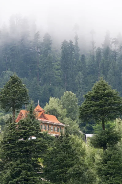 Дом в горах, покрытый облаками — стоковое фото